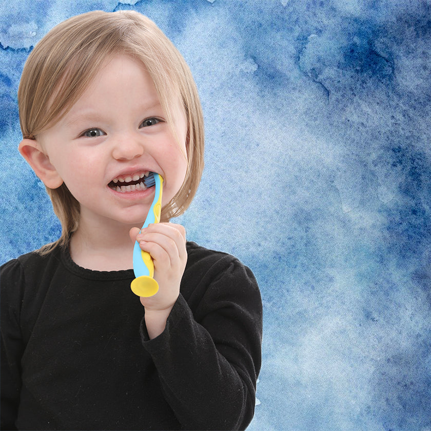 little girl smiling and brushing her teeth